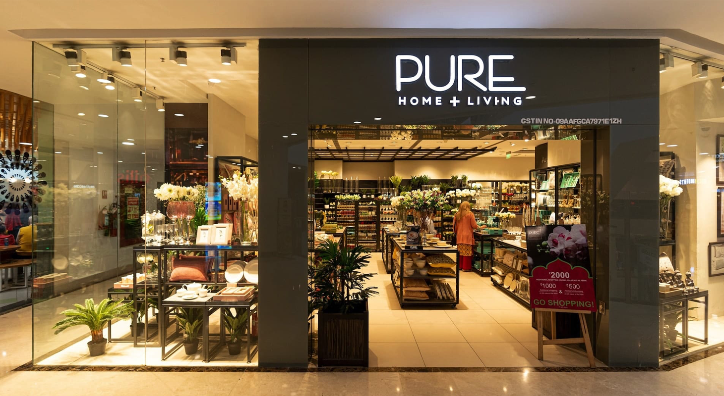 Pure Home + Living store featuring JUMPINGGOOSE-designed in-store signage and digital communication for a premium retail experience.